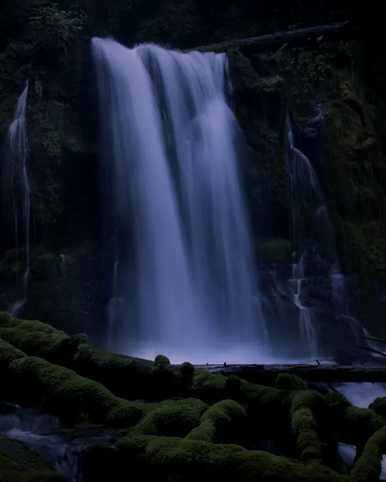 A waterfall falling over moss-covered rock